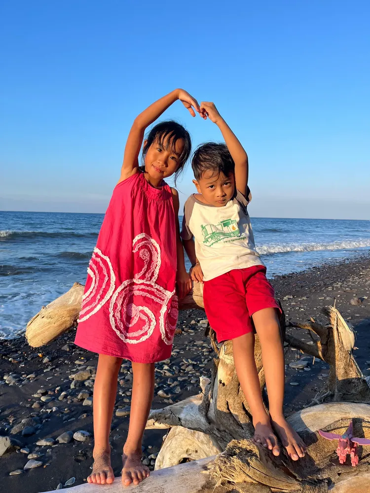Children on a black-sand beach in Bali